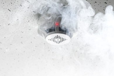 Image of Fire alarm system. Detector on ceiling triggered by smoke