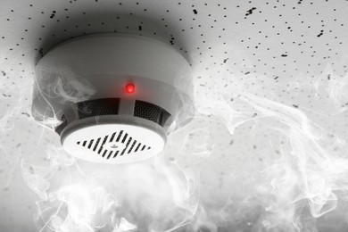 Image of Fire alarm system. Detector on ceiling triggered by smoke