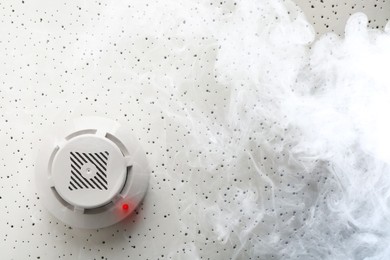 Image of Fire alarm system detector on ceiling triggered by smoke, bottom view
