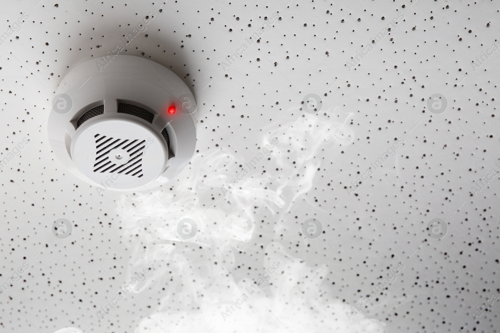 Fire alarm system detector on ceiling triggered by smoke Image of Fire alarm system detector on ceiling triggered by smoke