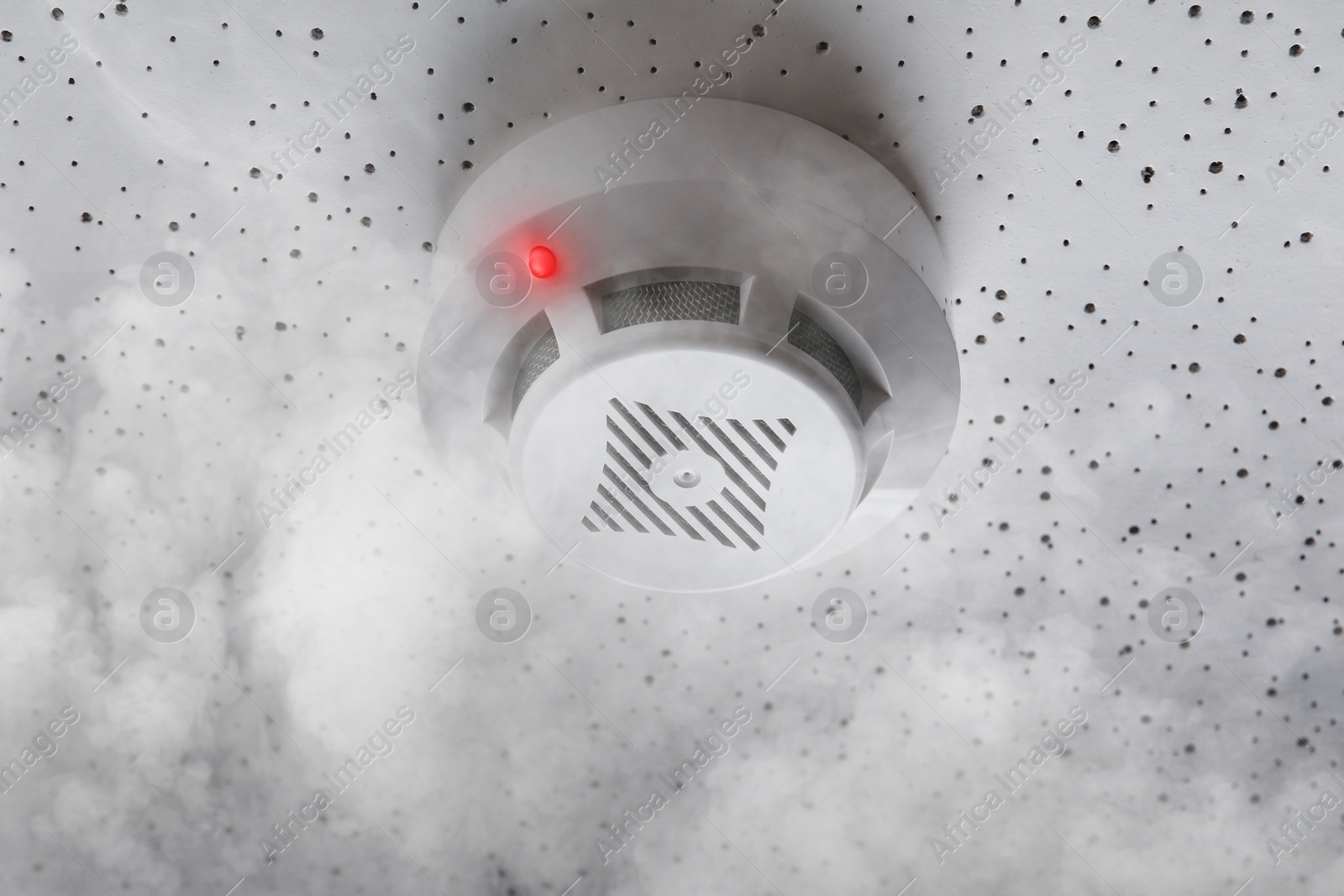 Fire alarm system detector on ceiling triggered by smoke Image of Fire alarm system detector on ceiling triggered by smoke