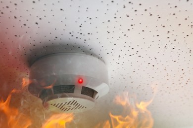 Image of Fire alarm system. Detector on ceiling triggered by smoke and flame