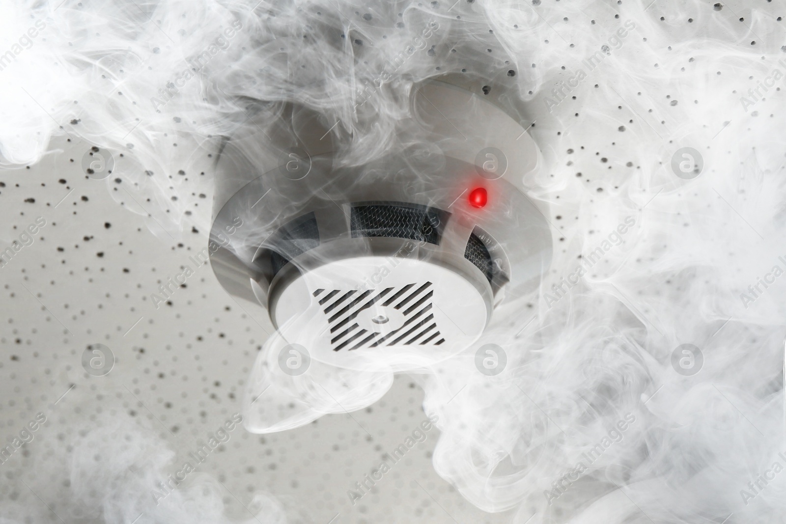 Fire alarm system. Detector on ceiling triggered by smoke Image of Fire alarm system. Detector on ceiling triggered by smoke