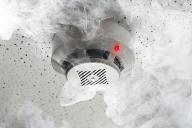 Image of Fire alarm system. Detector on ceiling triggered by smoke