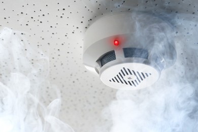 Image of Fire alarm system. Detector on ceiling triggered by smoke