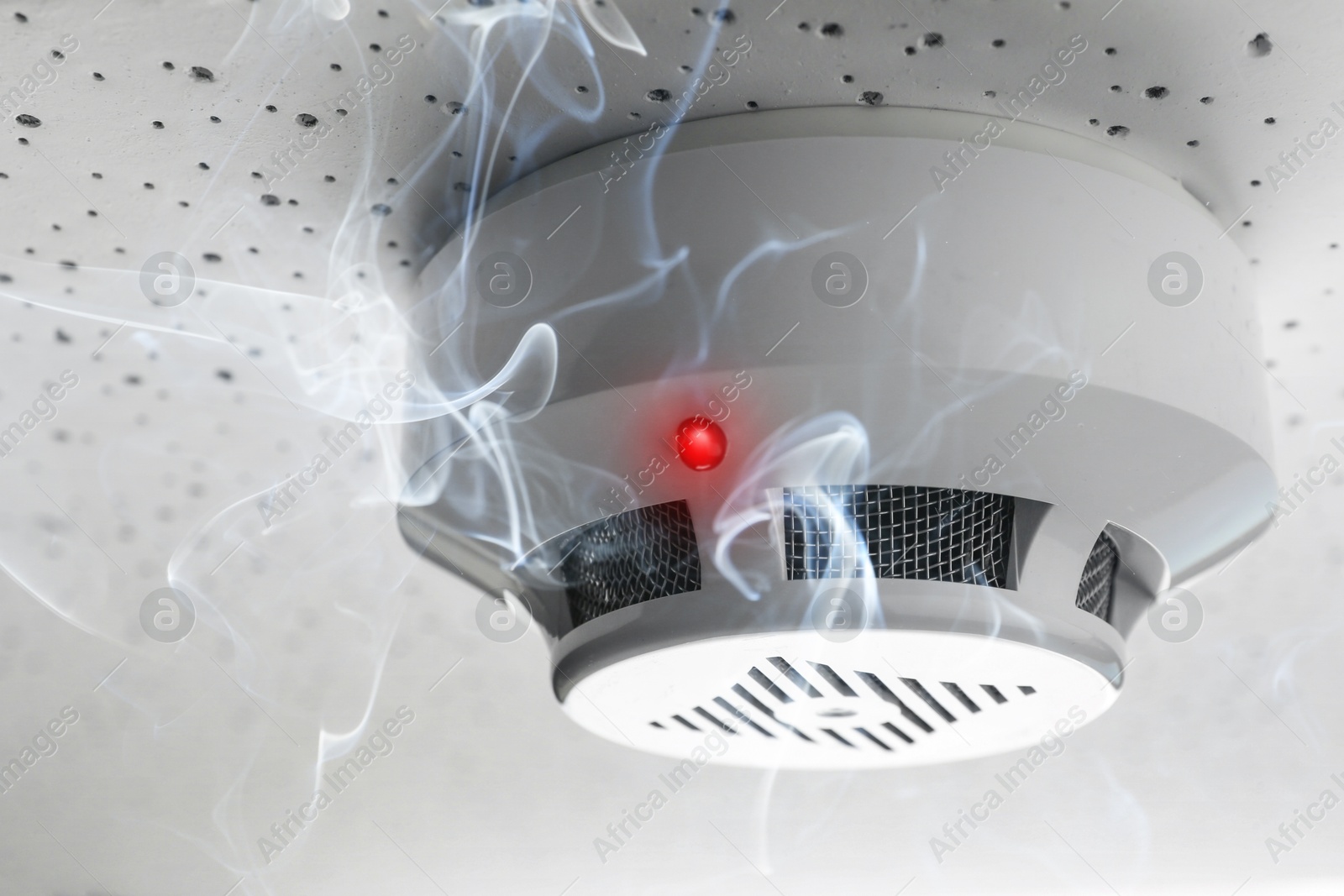 Fire alarm system. Detector on ceiling triggered by smoke Image of Fire alarm system. Detector on ceiling triggered by smoke