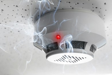 Image of Fire alarm system. Detector on ceiling triggered by smoke