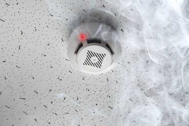 Image of Fire alarm system. Detector on ceiling triggered by smoke