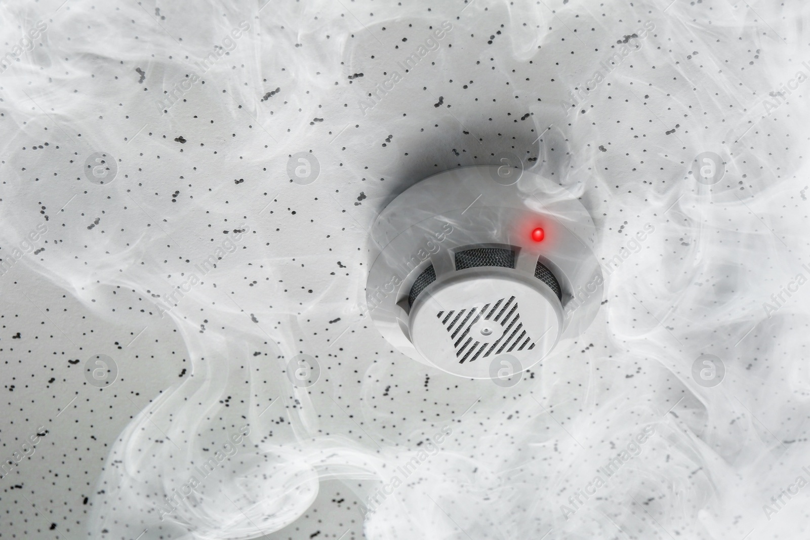 Fire alarm system. Detector on ceiling triggered by smoke Image of Fire alarm system. Detector on ceiling triggered by smoke