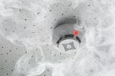 Image of Fire alarm system. Detector on ceiling triggered by smoke