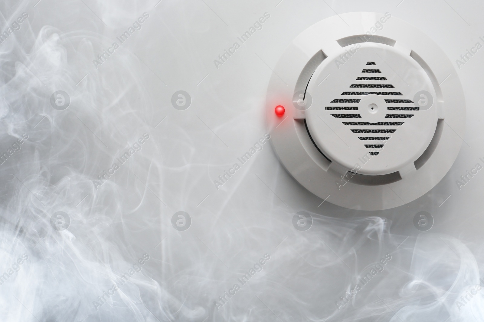 Fire alarm system. Detector on ceiling triggered by smoke, bottom view Image of Fire alarm system. Detector on ceiling triggered by smoke, bottom view