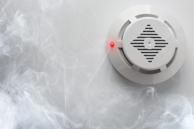 Image of Fire alarm system. Detector on ceiling triggered by smoke, bottom view