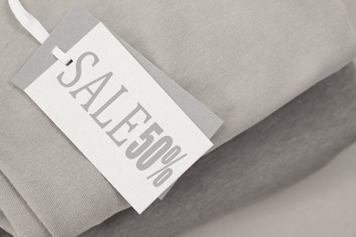 Image of White Sale tag and clothes, closeup view