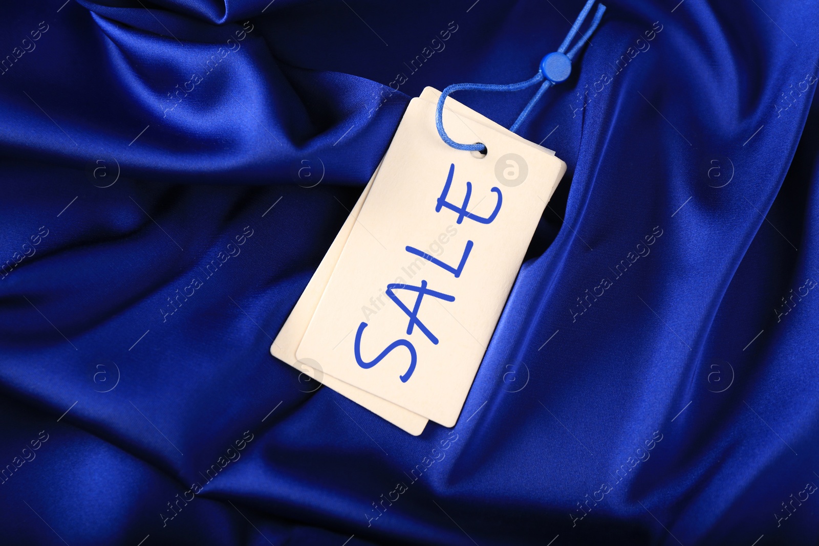 White Sale tag on silky skirt, top view Image of White Sale tag on silky skirt, top view