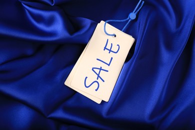 Image of White Sale tag on silky skirt, top view