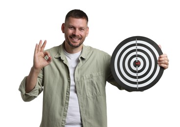 Photo of Targeting. Man with dart board and arrow showing ok gesture on white background