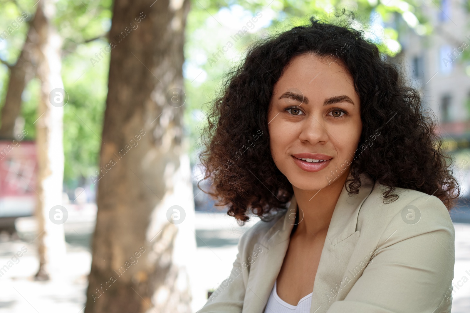 Photo of Portrait of smiling Latin American woman outdoors. Space for text