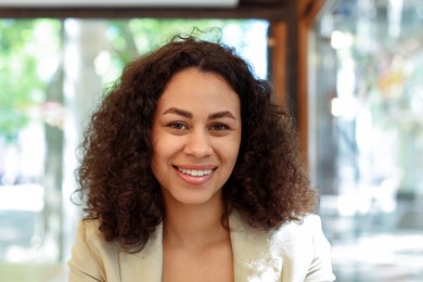 Photo of Portrait of smiling Latin American woman in cafe