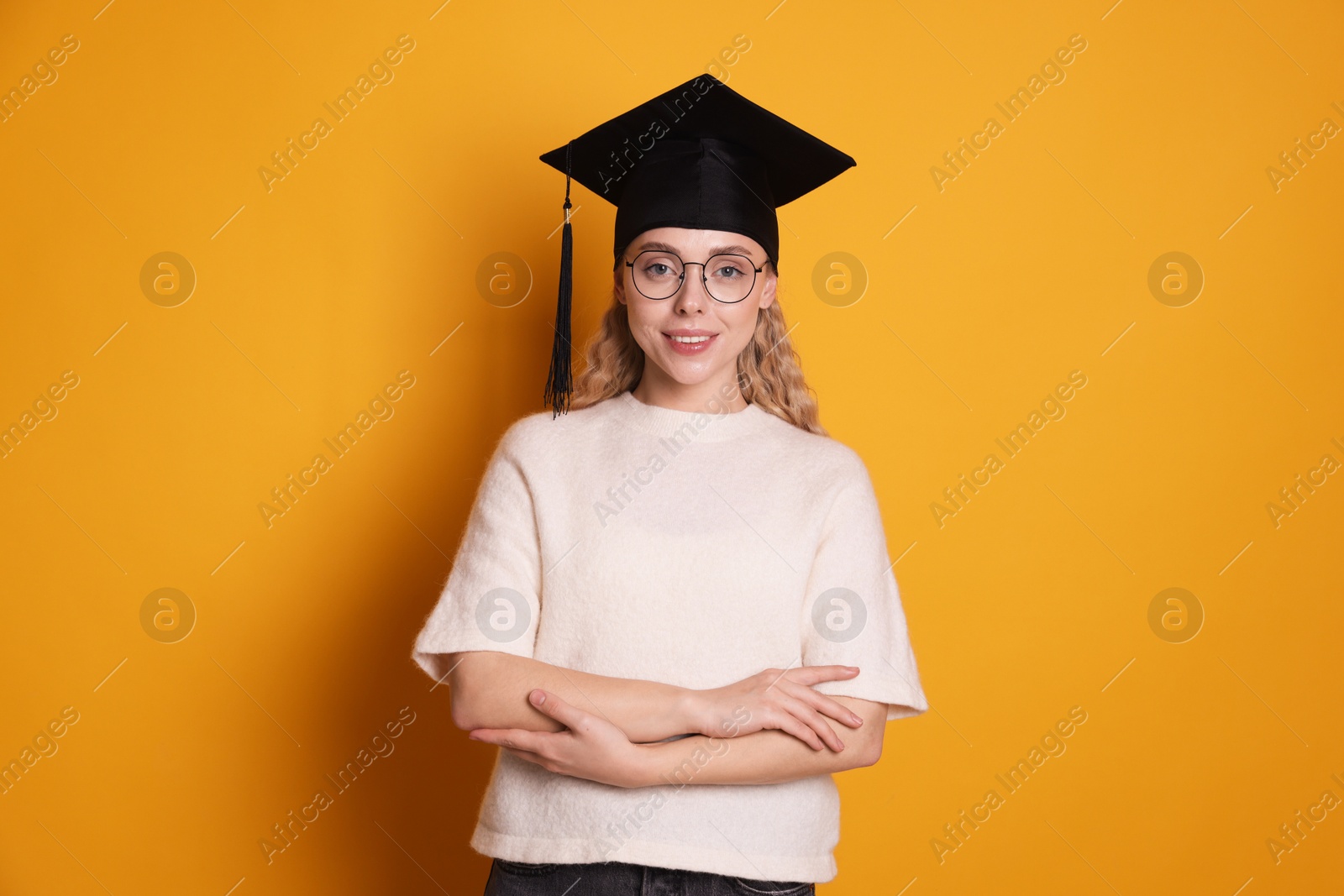 Happy student after graduation on orange background Photo of Happy student after graduation on orange background