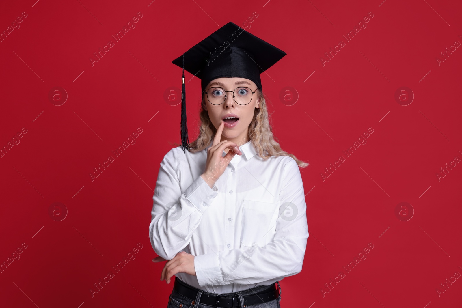 Emotional student after graduation on red background Photo of Emotional student after graduation on red background