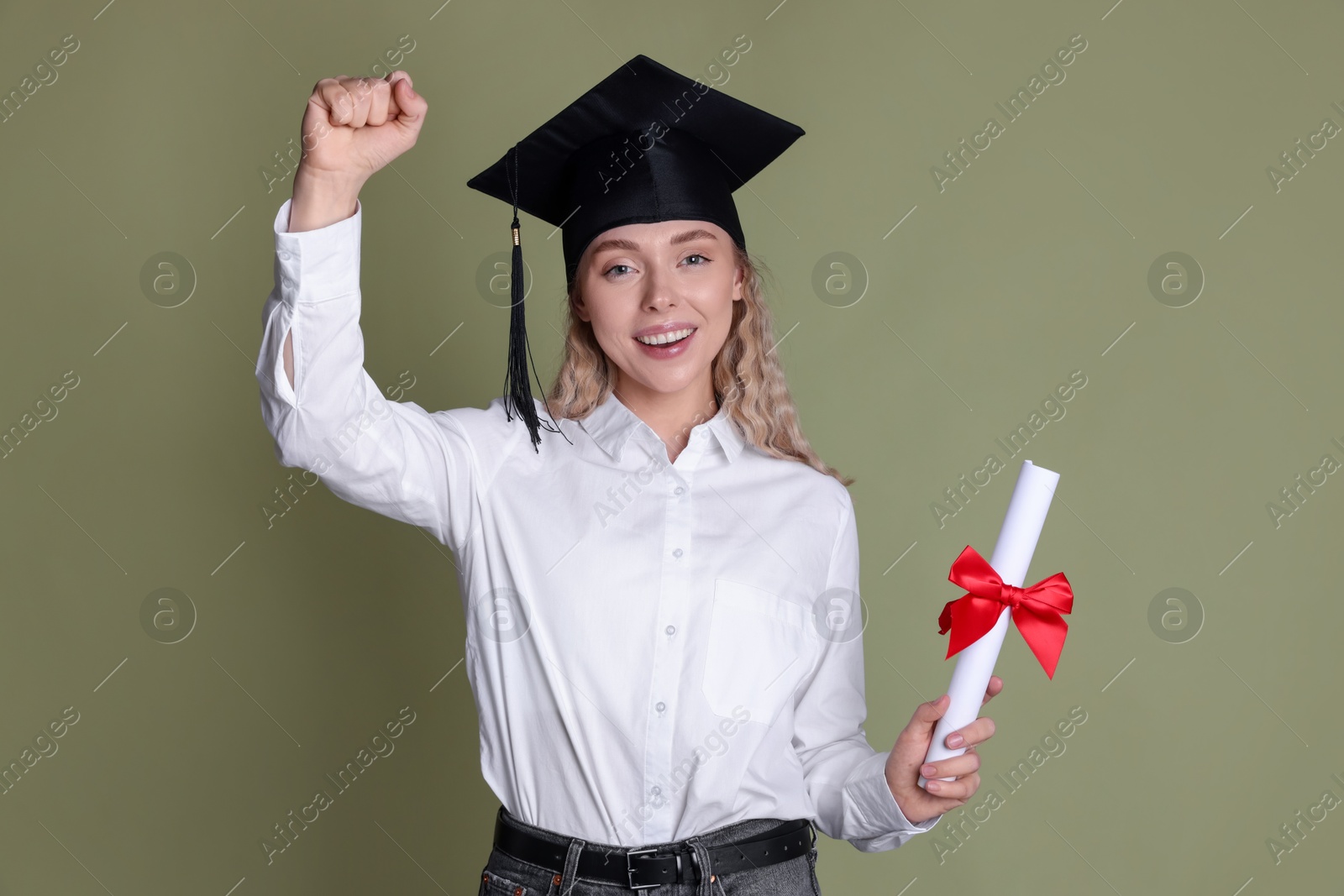 Happy student with diploma after graduation on green background Photo of Happy student with diploma after graduation on green background