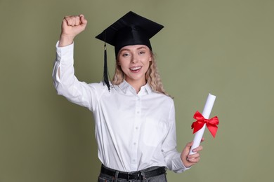 Photo of Happy student with diploma after graduation on green background