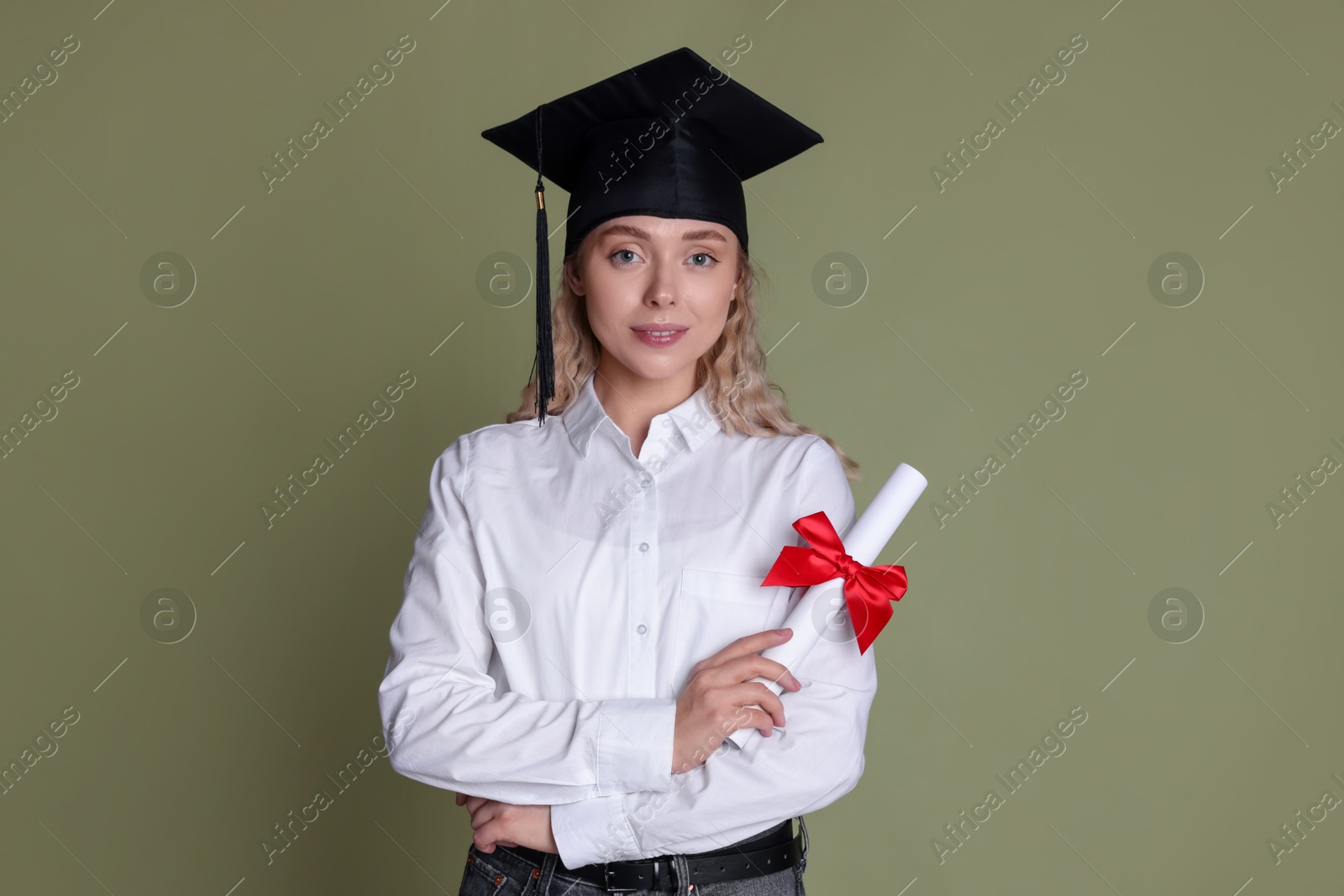 Happy student with diploma after graduation on green background Photo of Happy student with diploma after graduation on green background