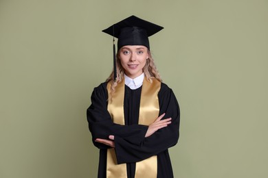 Photo of Happy student after graduation on green background