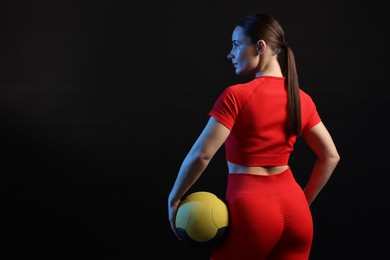 Photo of Woman with medicine ball on black background. Space for text