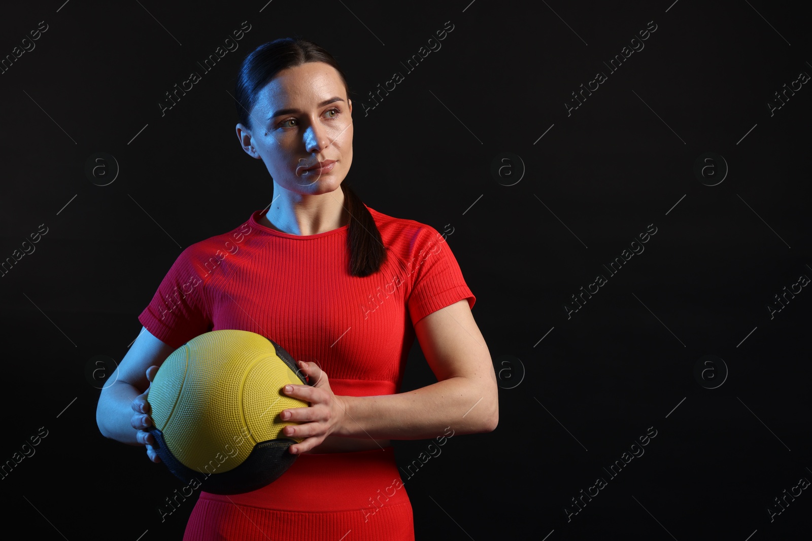 Woman with medicine ball on black background. Space for text Photo of Woman with medicine ball on black background. Space for text