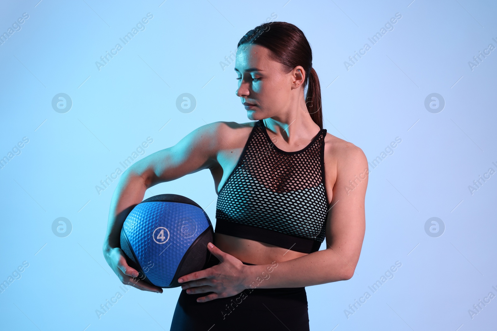 Woman with medicine ball on color background Photo of Woman with medicine ball on color background