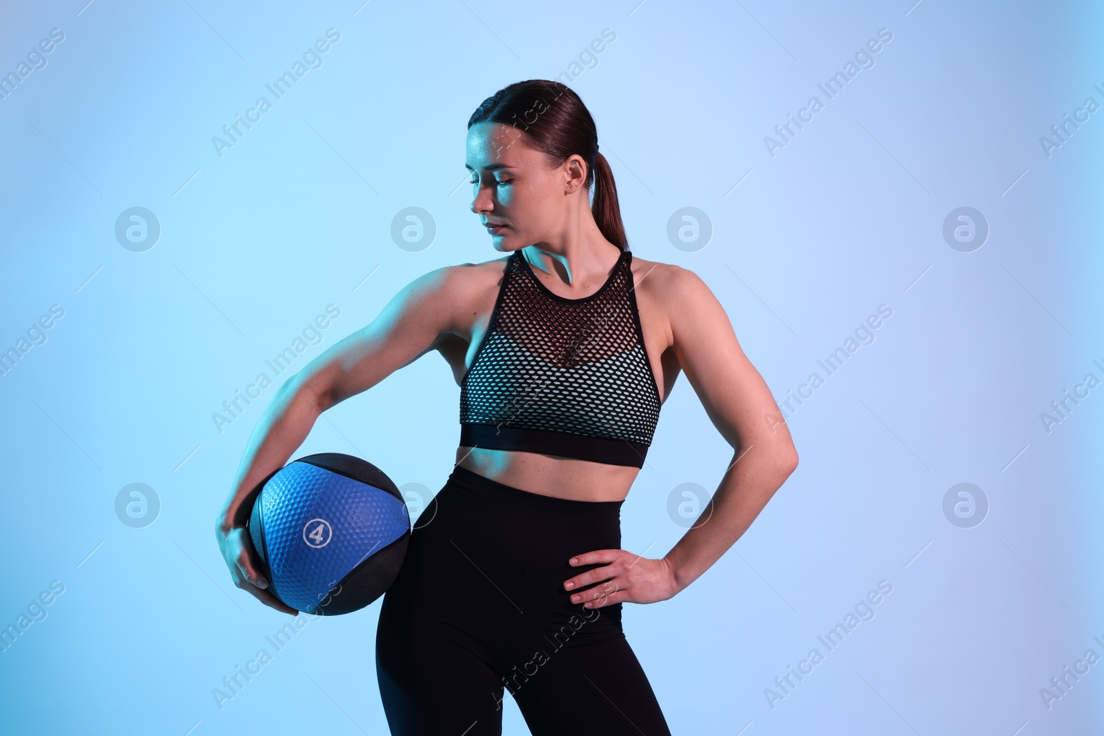 Woman with medicine ball on color background Photo of Woman with medicine ball on color background