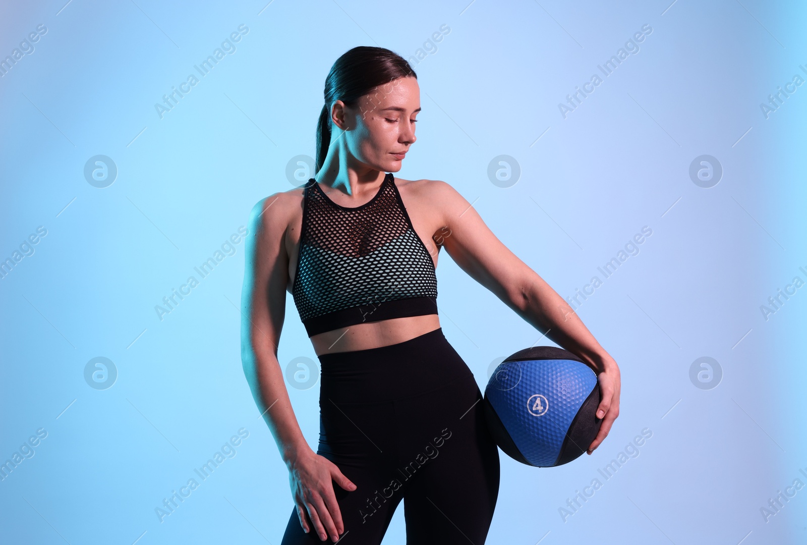 Woman with medicine ball on color background Photo of Woman with medicine ball on color background