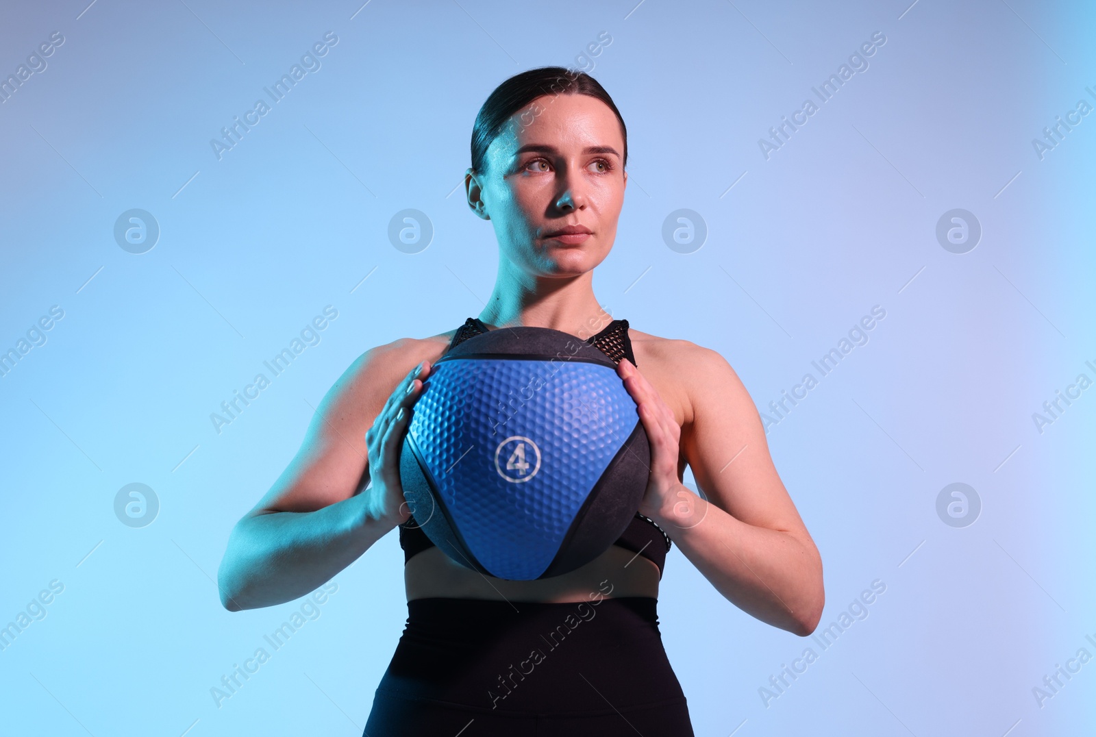 Woman with medicine ball on color background Photo of Woman with medicine ball on color background