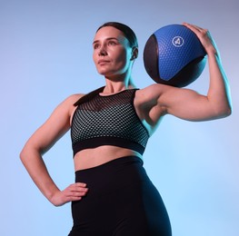 Photo of Woman with medicine ball on color background, low angle view