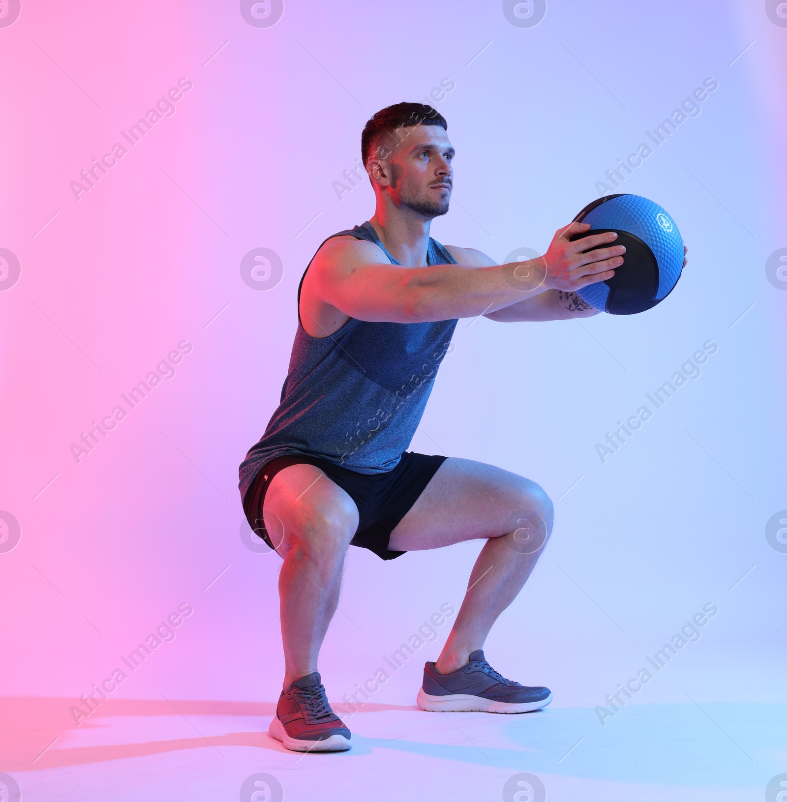 Man exercising with medicine ball on color background Photo of Man exercising with medicine ball on color background