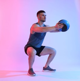 Photo of Man exercising with medicine ball on color background