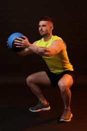 Photo of Man exercising with medicine ball on black background