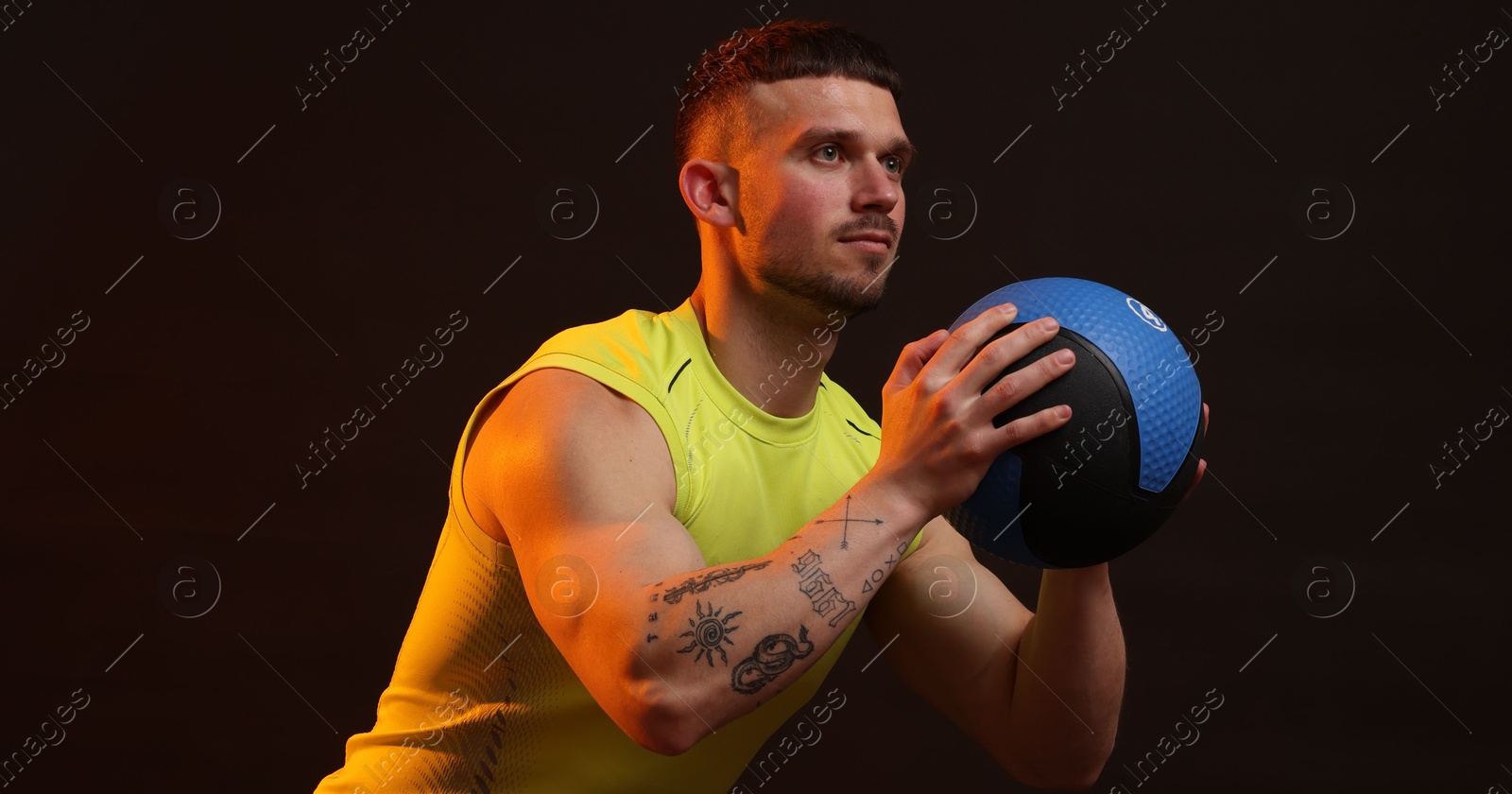 Man with medicine ball on black background Photo of Man with medicine ball on black background
