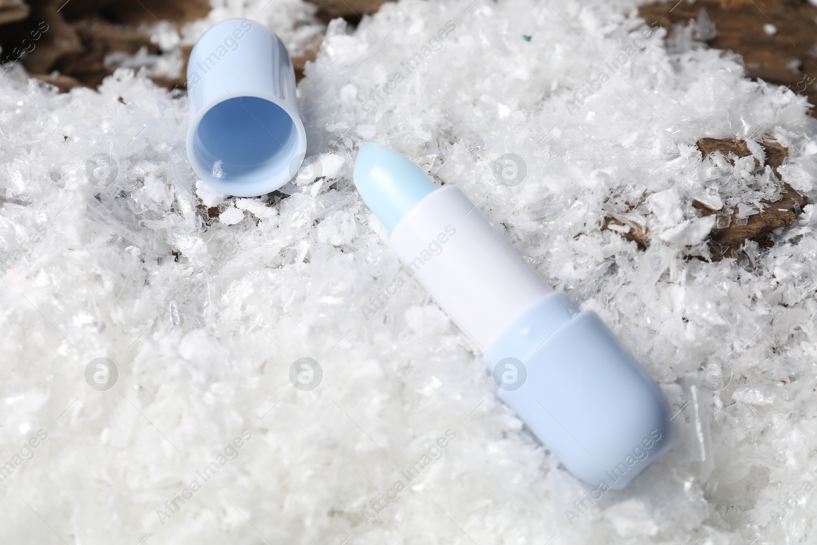 Moisturizing lip balm on artificial snow, closeup. Winter care Photo of Moisturizing lip balm on artificial snow, closeup. Winter care