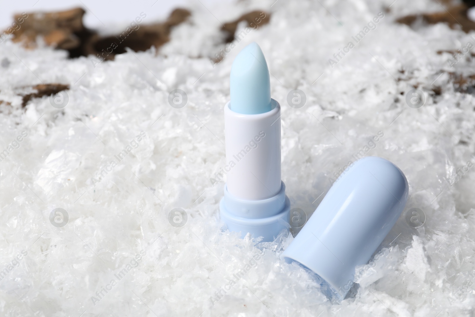 Moisturizing lip balm on artificial snow, closeup. Winter care Photo of Moisturizing lip balm on artificial snow, closeup. Winter care