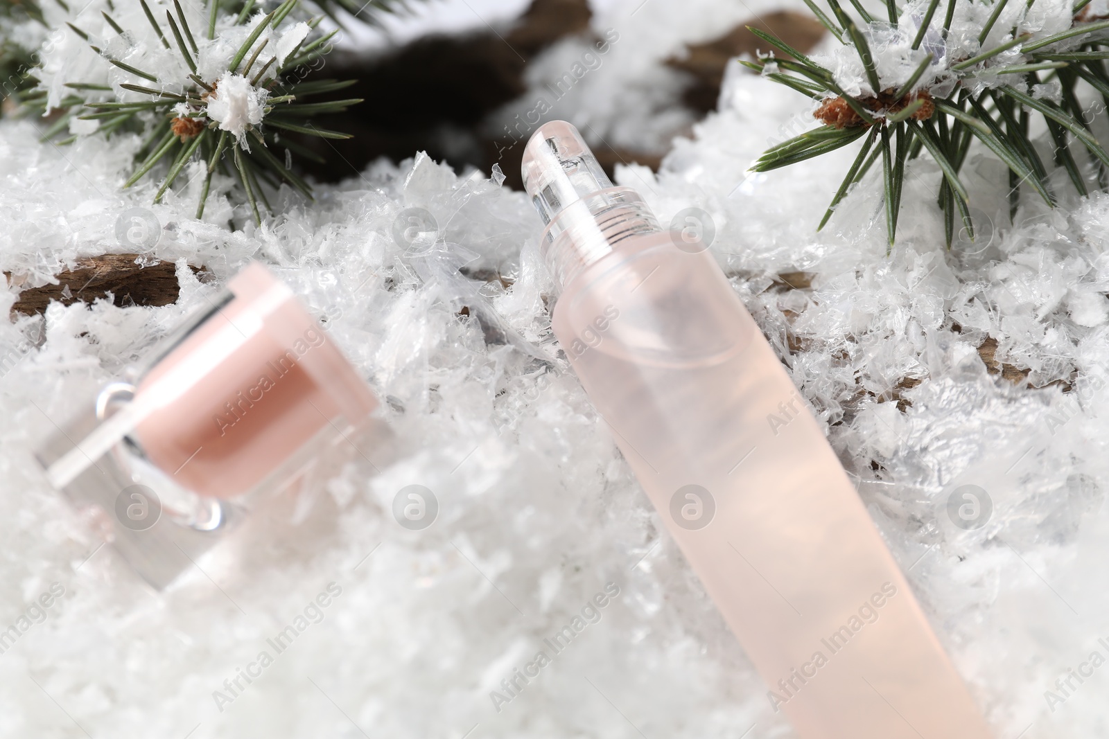 Moisturizing lip balm and fir tree branches on artificial snow, closeup. Winter care Photo of Moisturizing lip balm and fir tree branches on artificial snow, closeup. Winter care