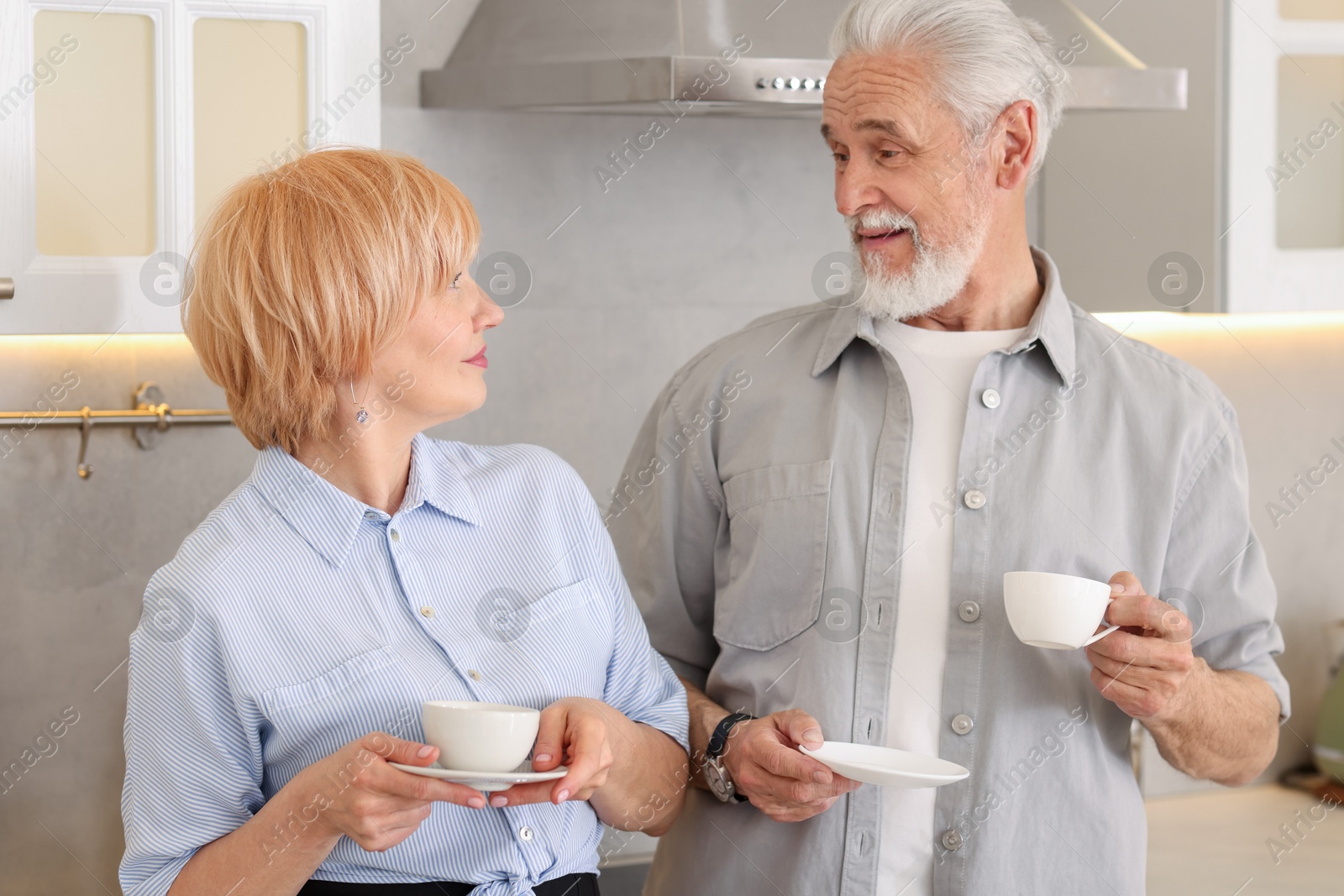 Photo of Lovely senior couple with cups of coffee in kitchen