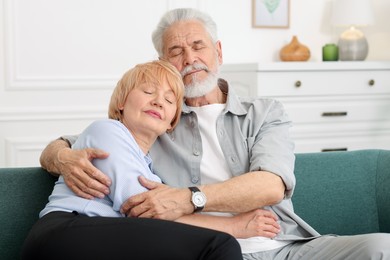 Photo of Lovely senior couple together on sofa at home