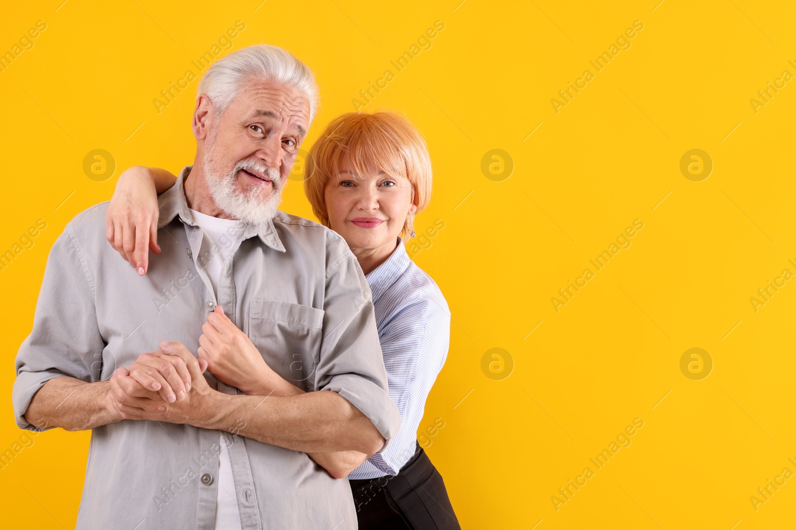 Photo of Lovely senior couple together on yellow background, space for text