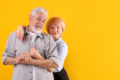 Photo of Lovely senior couple together on yellow background, space for text