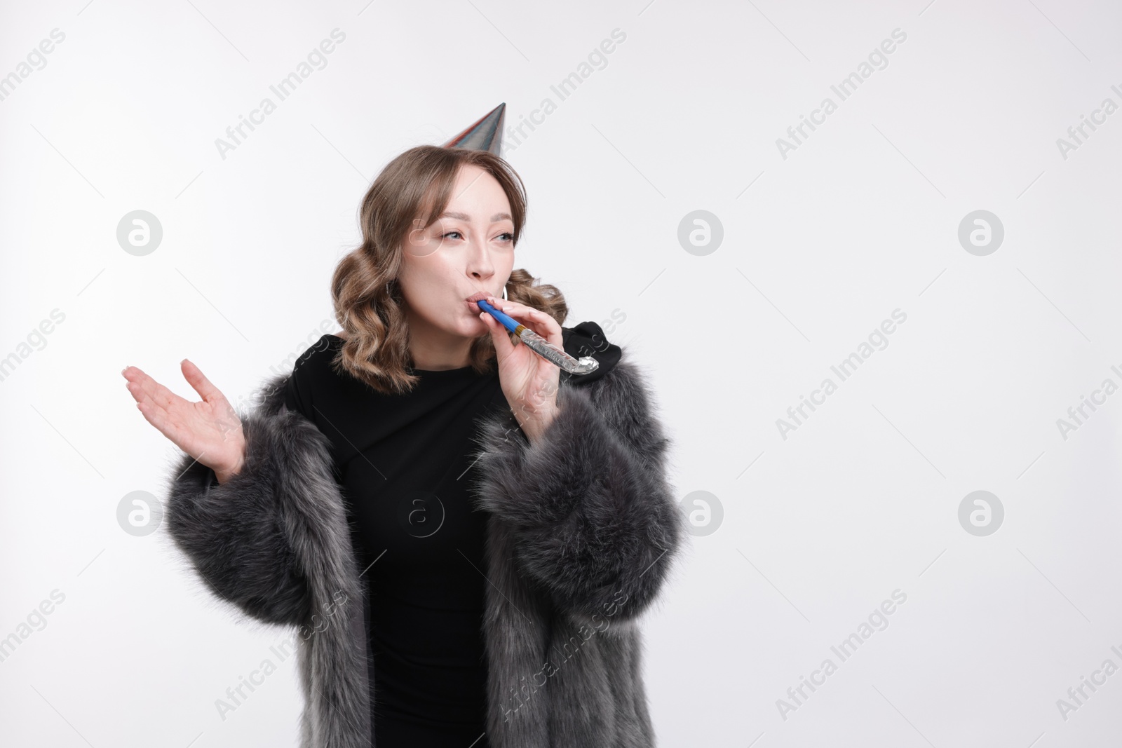 Birthday celebration. Woman with party horn on white background. Space for text Photo of Birthday celebration. Woman with party horn on white background. Space for text