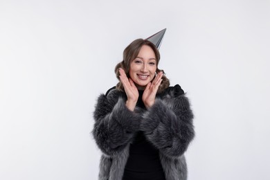 Photo of Birthday celebration. Happy woman with party cone on white background