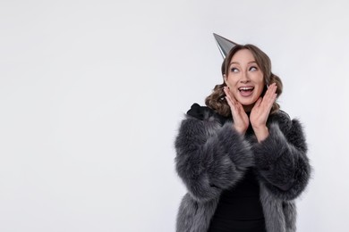 Photo of Birthday celebration. Excited woman with party cone on white background. Space for text
