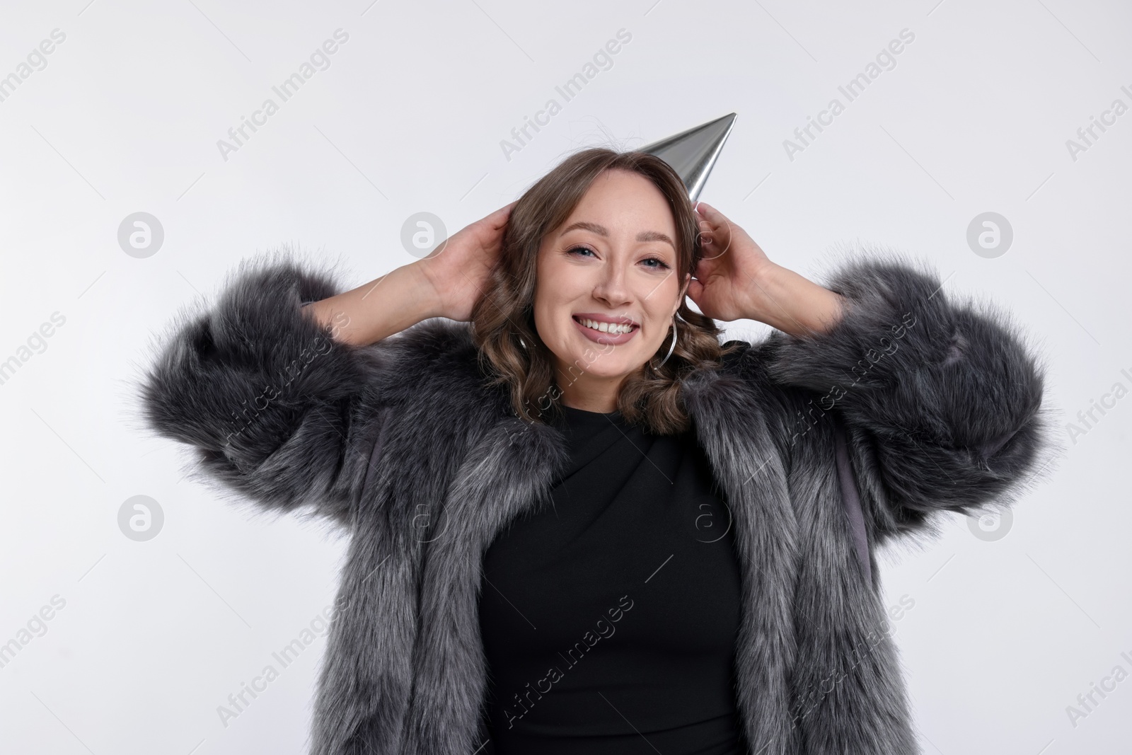 Photo of Birthday celebration. Happy woman with party cone on white background
